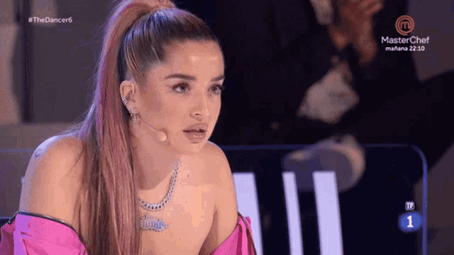 a woman in a pink top is on a masterchef tv show
