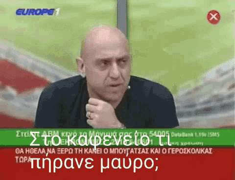 a bald man is sitting in front of a tv screen that says europe 1