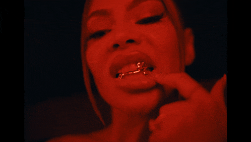 a close up of a woman 's mouth with a gold ring on her teeth