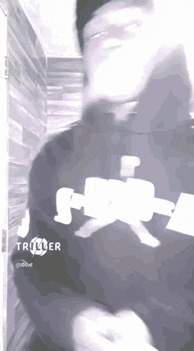 a man wearing a black shirt with the word triller on it
