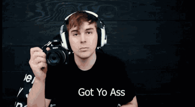 a man wearing headphones is holding a flashlight and the words got yo ass are above him