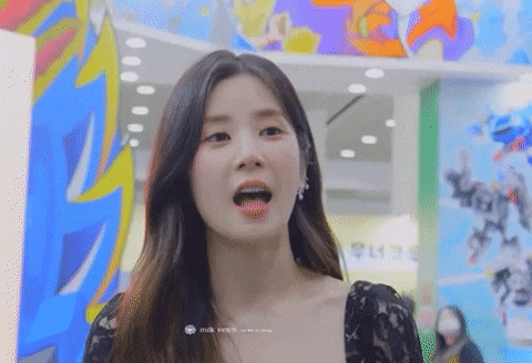 a close up of a woman 's face with her mouth open in front of a colorful wall .