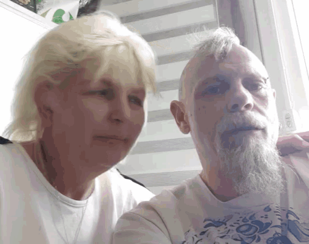 a man with a beard and a woman with blonde hair are posing for a photo