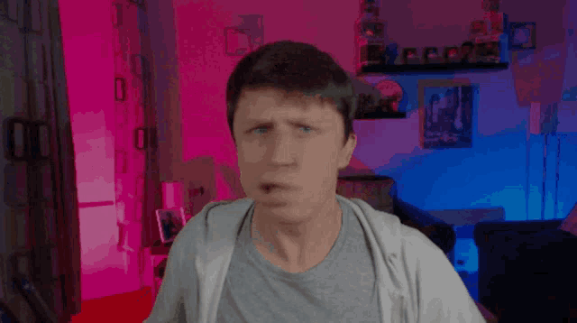 a man in a gray shirt is standing in a living room
