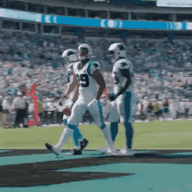 a football player with the number 19 on his jersey is walking on the field
