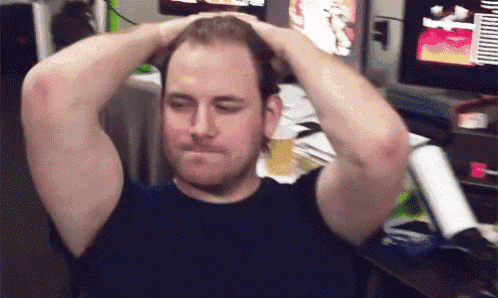 a man in a black shirt is holding his head with both hands