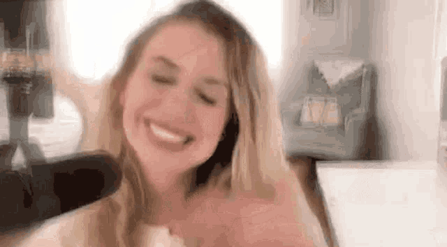 a woman is smiling and making a funny face in a room .