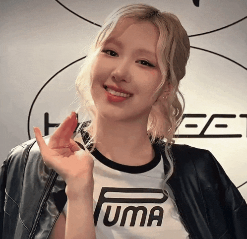 a woman wearing a black jacket and a white shirt that says uma