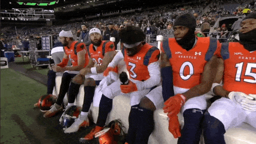 a group of seattle players sit on a bench