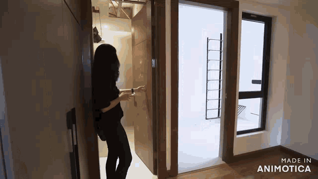 a woman opens a door in a room with the words made in animatica on the bottom