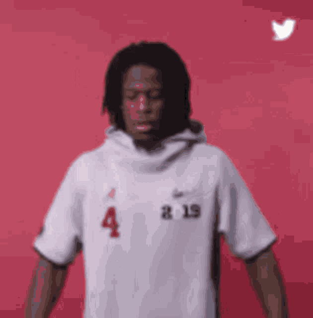 a man wearing a white hoodie with the number 4 on it
