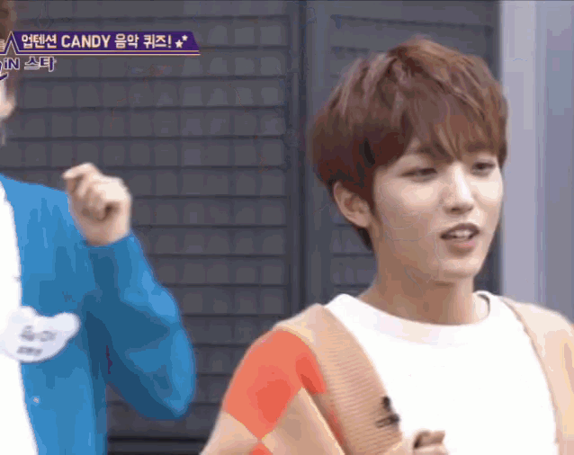 a boy in a white shirt is standing next to another boy in a blue jacket and a sign that says candy