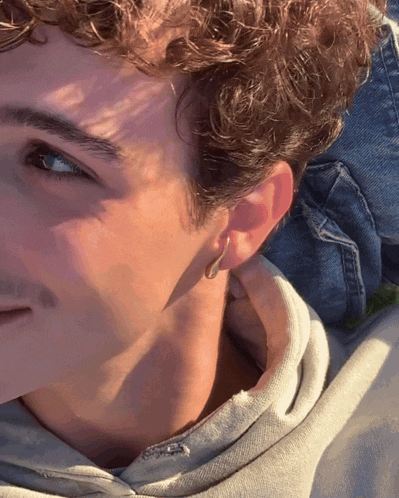 a close up of a young man 's ear with a hoop earring