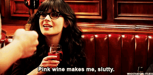 a woman with glasses is holding a glass of pink wine and says pink wine makes me slutty