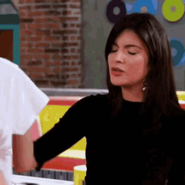a woman in a black sweater is standing next to a man .