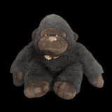a stuffed gorilla with a bow tie is sitting on a black surface