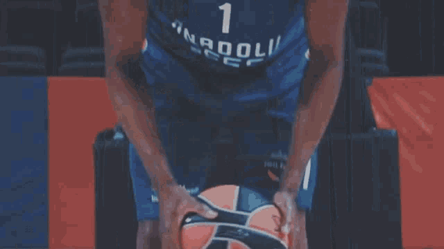 a basketball player with the number 1 on his jersey holds a basketball