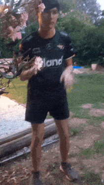 a man wearing a black shirt that says " land " on it