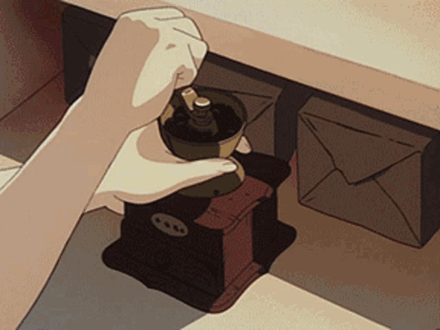 a person grinding coffee in a coffee grinder on a table
