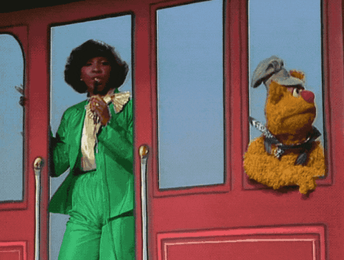 a woman in a green suit is standing next to a stuffed dog