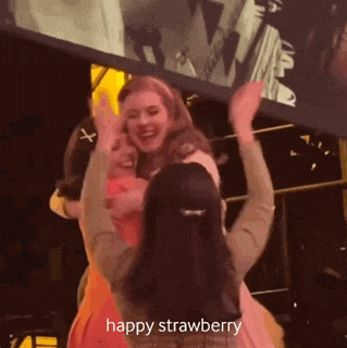 a group of women are dancing in a room with the words happy strawberry in the corner .