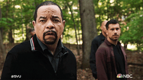 a man with a beard is standing in the woods with the nbc logo in the corner