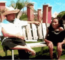 a man and a woman are sitting on a bench in a park