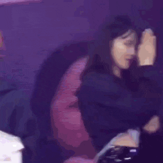 two women are standing next to each other on a stage and giving each other a high five .
