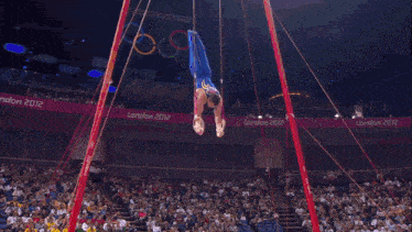a gymnast performs a trick in front of a crowd at the london 2012 olympic games