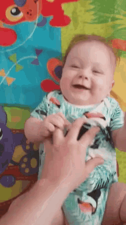 a baby is smiling while being held by a woman