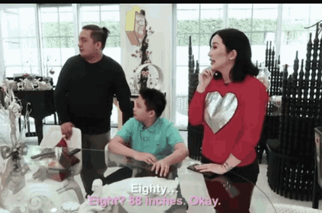 a woman in a red heart sweater talks to a boy