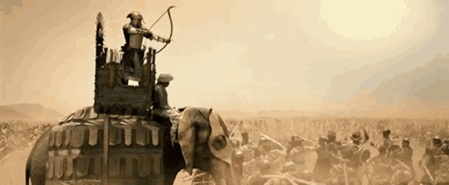 a man with a bow and arrow is riding an elephant