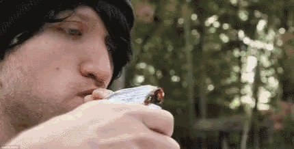 a man is smoking a cigarette with a lighter .