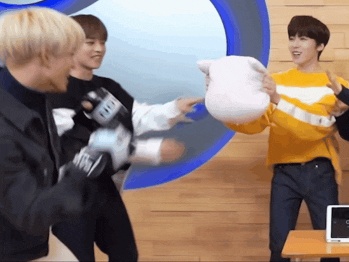 a man in a yellow sweater is holding a stuffed animal that says ' fifi ' on it