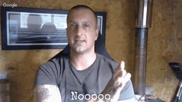 a man wearing a t-shirt that says noooo on it is sitting in front of a google logo
