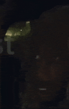 a close up of a man 's face in a car with a flashlight on .