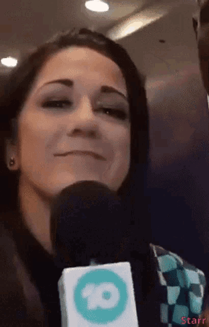 a woman holding a microphone with a starr logo