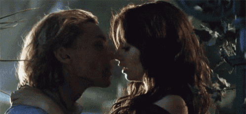 a man and a woman are kissing each other in a dark room .