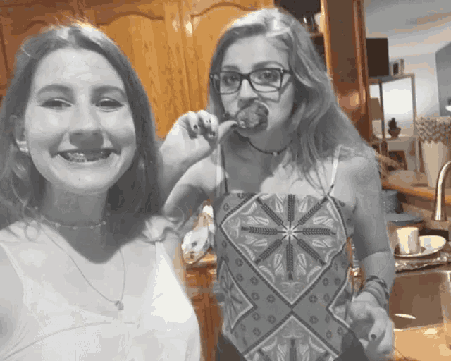 a girl with braces on her teeth holds a piece of cake in her mouth