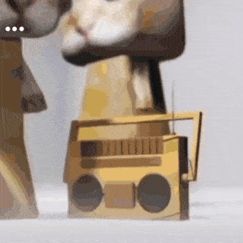 a statue of a cat is sitting on top of a radio