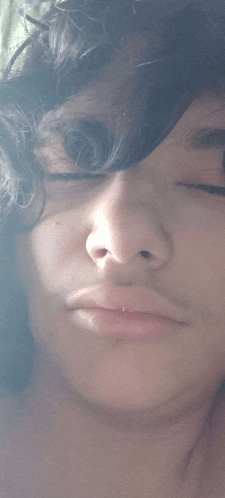a close up of a man 's face with his eyes closed and his hair visible