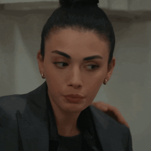 a woman with a bun on her head is wearing earrings