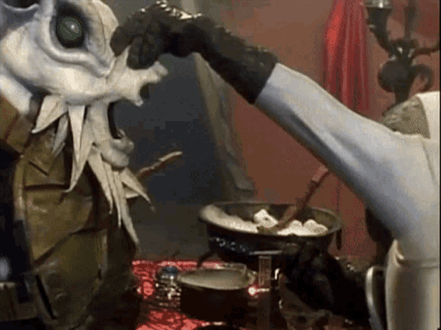 a monster with a green eye is being eaten by someone