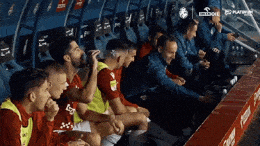 a group of soccer players are sitting in a locker room sponsored by orlen oil and platinum
