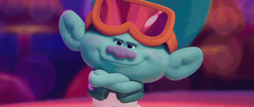 a troll from the movie trolls is wearing a pair of goggles and smiling .