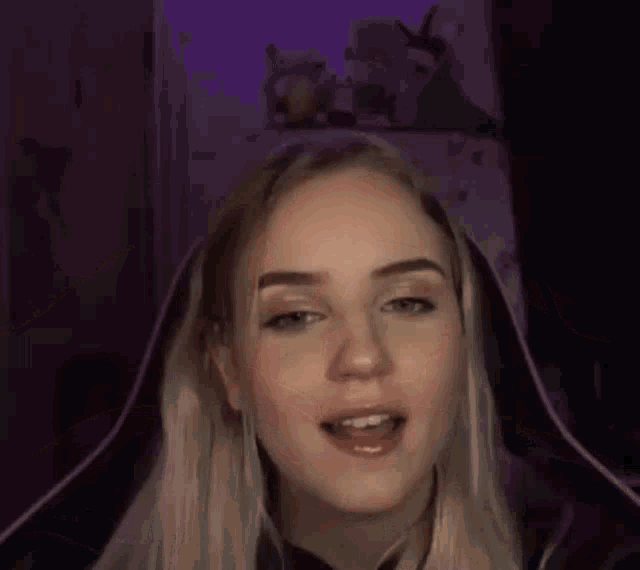 a woman is wearing headphones and a hood over her head .