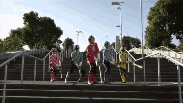 a group of power rangers are standing on stairs