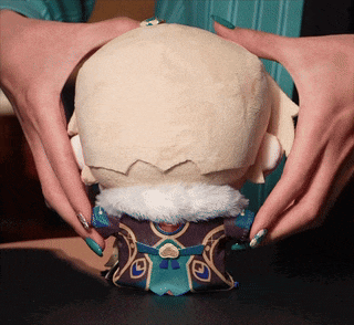 a person with green nails is holding a stuffed animal with a crown on its head