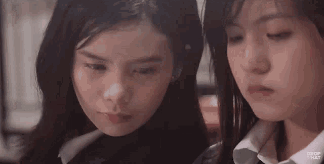two girls are looking at each other and making faces .