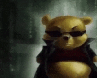 a teddy bear wearing sunglasses and a jacket is standing in a dark room .